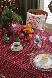 Close-up of red and black plaid Christmas tablecloth with festive table decorations