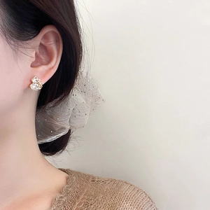 Elegant gold-plated gourd stud earrings with zircons shown on a model's ear