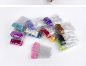 Close-up of colorful disposable eyelash brushes with glitter crystal handles in a set