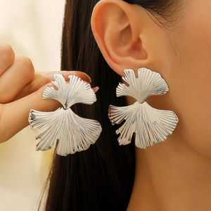 Statement silver ginkgo leaf earrings with metallic texture shown on model