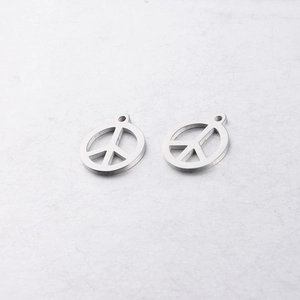 Gros plan de pendentifs signe de paix en acier inoxydable poli pour bijoux artisanaux