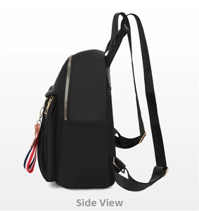 Side view of black oxford backpack featuring gold zippers and a cute bear charm pendant