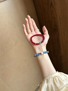 Detail of red and blue agate crystal beaded bracelet on hand with vintage style