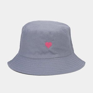 Détail de la broderie de cœur rose sur un chapeau bob en coton gris avec surpiqûres