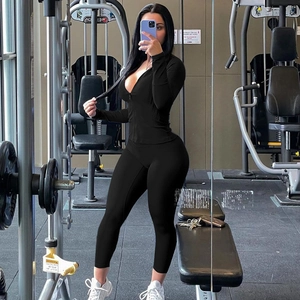 Women's black seamless two-piece yoga set featuring zipper neck top and high-waist leggings