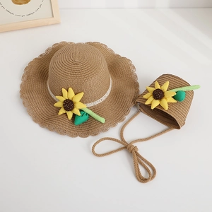 Flat lay of child straw sun hat and matching bag with sunflower lace details