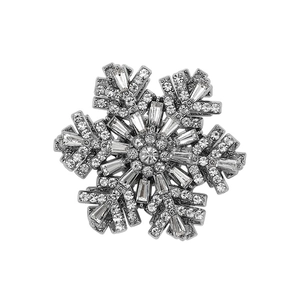 Elegant rotating snowflake brooch with silver metal and sparkling crystals on white background