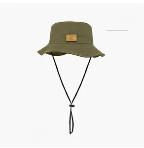 Detail of army green sun hat with adjustable black chin strap and square leather patch