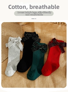 Close-up of baby knee high socks in four colors with large glittery decorative bows