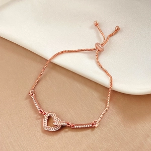 Detailed view of adjustable rose gold heart bracelet with sparkling crystals on satin