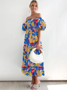 Detail of floral puff sleeve dress with colorful flower pattern and woven bag