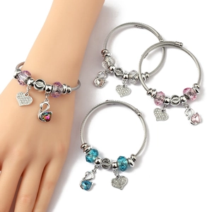 Detail of steel wire bracelets with crystal swan charms and colorful faceted beads