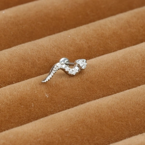 Detailed macro view of a silver snake cartilage earring with cubic zirconia inlay
