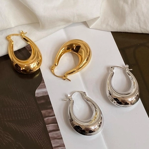 Minimalist thick U-shaped metallic hoop earrings in polished gold and silver finishes