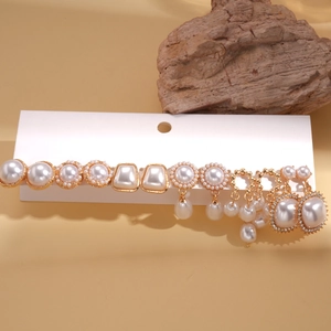 Detailed view of a 12-piece vintage gold earring set with white pearls on a display card