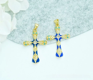 Detailed view of 18K gold plated snake head cross pendants with blue enamel