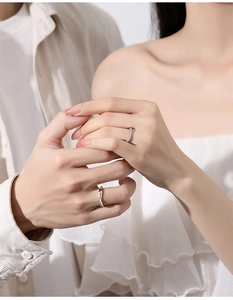 Close-up of minimalist S925 silver Mobius rings worn on hands for a stylish couple look