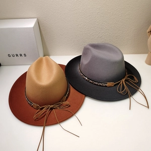 Detailed view of fedora hat with metal rivets and leather bow on wool felt material