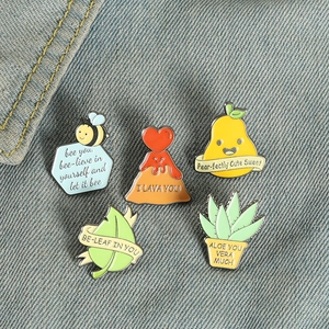 Detailed close-up of 5 creative cartoon enamel pins on denim, featuring punny quotes