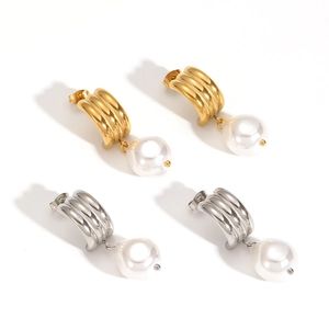 Gold and silver layered hoop earrings with round white pearl pendants on white background