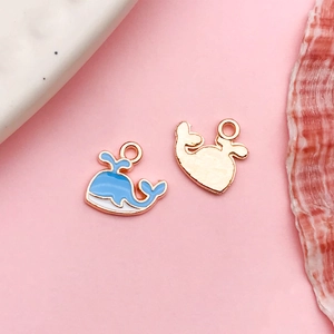 Macro detail of blue enamel whale pendant and gold metal base for DIY jewelry