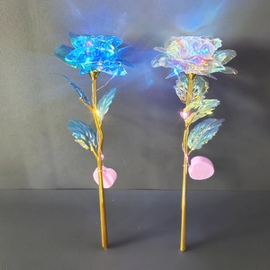 Close-up of blue and iridescent gold foil roses with LED lights on pink heart bases