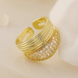 Wide geometric 18K gold plated ring with pave zircons on soft white fabric background
