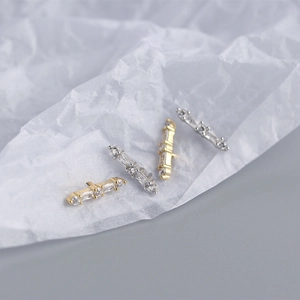 Macro shot of minimalist S925 sterling silver bar earrings in gold and silver finish