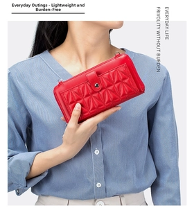 Detail of red quilted leather wallet with secure metal buckle and functional zipper closure