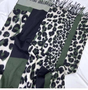 Detail of leopard print scarf with fringe edge, featuring dark green and black color blocks