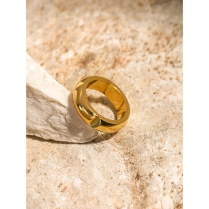 Minimalist 18k gold plated stainless steel ring with wide beveled design on stone background