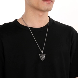 Close-up of a men's punk style stainless steel bear head pendant on a silver chain
