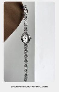 Macro detail of silver floral bracelet watch featuring diamond-set camellia links