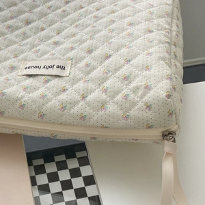 Floral quilted cotton makeup bag with a minimalist design and ribbon zipper pull