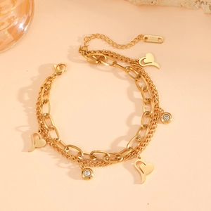 Dettaglio del bracciale a doppia catena in acciaio inossidabile dorato con cuori e zirconi