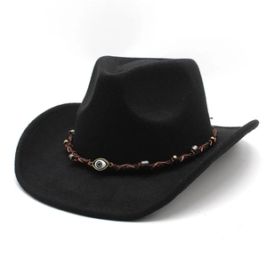 Dettaglio del cappello da cowboy nero con fascia in pelle intrecciata e ciondolo occhio