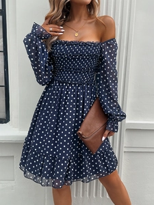 Detail of navy blue polka dot off-shoulder dress with smocked bodice and chiffon sleeves