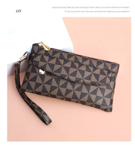 Detail of checkered PU leather clutch bag featuring golden zipper and wristlet strap