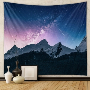 Detailed texture of bohemian tapestry showing galaxy night sky and snowy mountain landscape