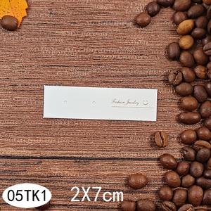 Detail view of 2x7cm white jewelry display card with Fashion Jewelry logo on wood