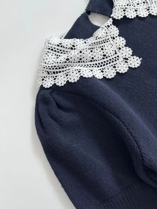 Detail of navy knit top featuring delicate white lace collar and fine hollow-out patterns