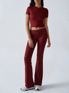 Detail of burgundy crop top and high-waist flared pants set with folded waist design