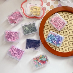 Macro shot of colorful macaron drip oil metal snap hair clips in clear storage boxes