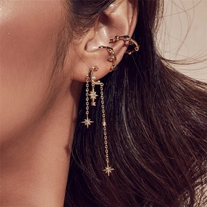 Detailed view of gold s925 silver star and moon chain tassel earrings with clear crystals