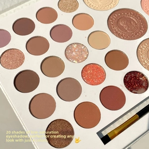 Detailed macro view of 20-color eyeshadow palette with dual-ended makeup brush