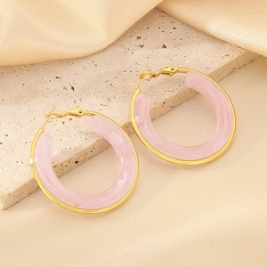 Detailed macro view of pink marble resin hoop earrings with gold metal frame