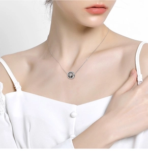 Close-up of S925 sterling silver Tree of Life necklace with white cubic zirconia on a model