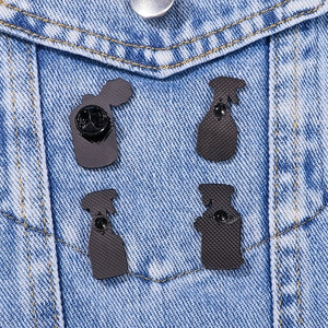 Set of 4 black enamel pins on denim jacket showing back butterfly clasp details