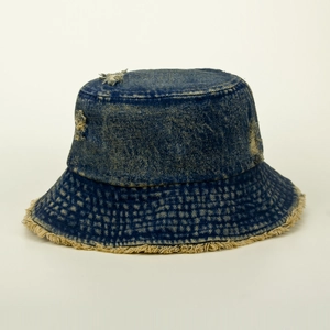 Detail of vintage washed blue denim bucket hat featuring distressed holes and frayed edges