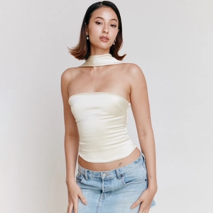 Detail van elegante crèmekleurige satijnen strapless top met bijpassende sjaal
